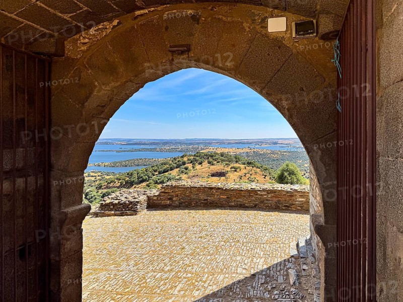 Stone arch with view of surrounding countryside and water seen from a castle, Monsaraz, Évora, Portugal