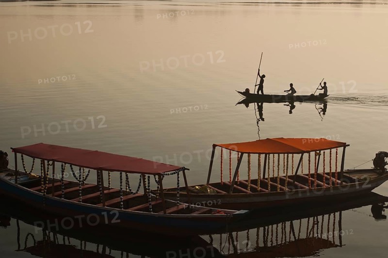 Fishermen are boating on the Mahanadi river (Chhattisgarh, India) . Foreground : tourboats