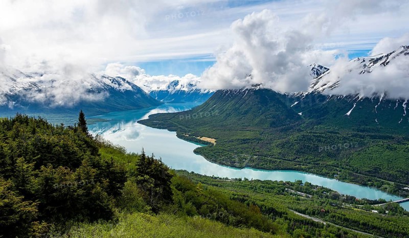 View of snowy mountains in spring and turquoise Kenai Lake with reflection, Slaughter Ridge Trail, Cooper Landing, Kenai Peninsula, Alaska, USA