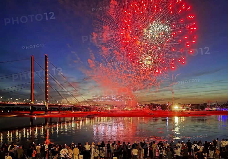 Rhine fair with Rheinkniebrücke, many people watch the colorful fireworks at night, Düsseldorf, North Rhine-Westphalia, Germany