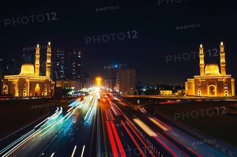 Night long exposure Sharjah Four Khalifas intersection.UAE futuristic architecture. Illuminated Masjid Abu Bakr Al Siddiq, Umar bin Al Khattab, Uthman bin Affan, Ali bin Abi Talib mosque light trails