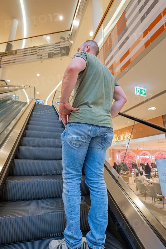 Man on an escalator in a modern shopping center, Milaneo, Stuttgart, Germany