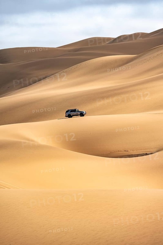 Off-road vehicle between sand dunes, sea of dunes, sandy desert, impressive desert landscape, Namib Naukluft Park, Namib Desert, Namibia