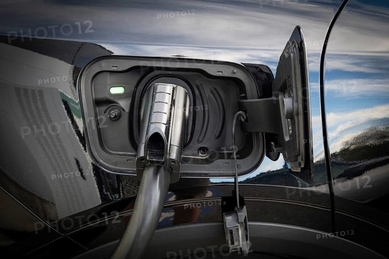 Fully electric Ford Explorer is being charged, charging cable in power tank, charging station for electric vehicles, Norway