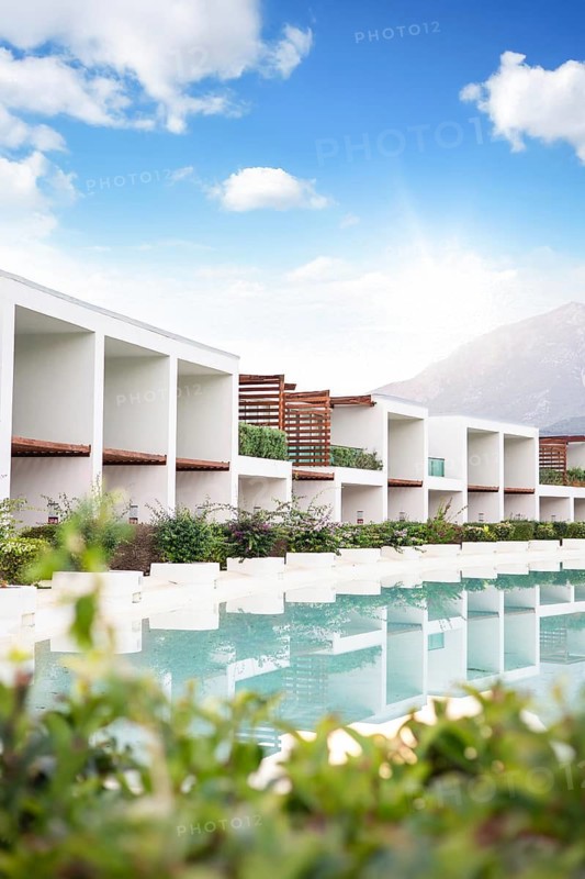 Hotel, Antalya, Turkiye. Modern resort located near calm waters. The design features open spaces that connect with nature. Flowers and greenery complement the surroundings
