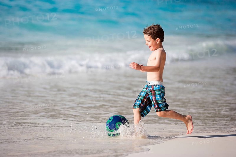 A young boy playing soccer on the beach, Seychelles, La Digue, La Digue, Indian Ocean, Seychelles