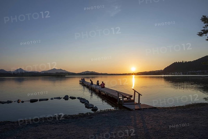 People enjoy sunset at Hopfensee near Füssen, Ostallgäu, Allgäu, Upper Swabia, Swabia, Bavaria, Germany