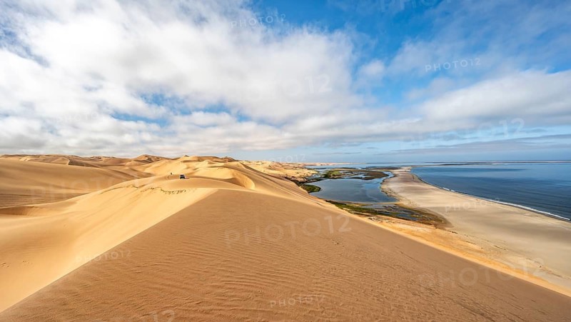 Sand dunes and sea, Atlantic coast and sandy desert with sea of dunes, view of lagoon at Sandwich Harbour, Namib Naukluft Park, Namib Desert, Namibia