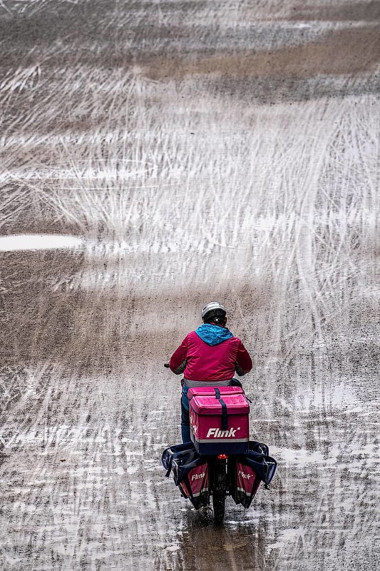 Dirt road, with many traces of two-wheelers, footprints, delivery service Flink Radkurier, wet, after rain, parallel, mixed up