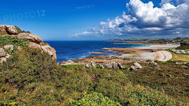 Panorama of a rocky coast with clear blue sky and calm sea, The coastal landscape near Cleder in Brittany