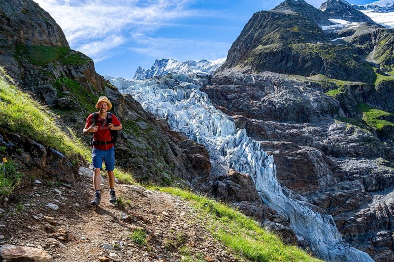 Mountaineers in front of picturesque high alpine mountain landscape with Lower Arctic Sea glacier, hiking to Schreckhornhütte, Bernese Oberland, Switzerland