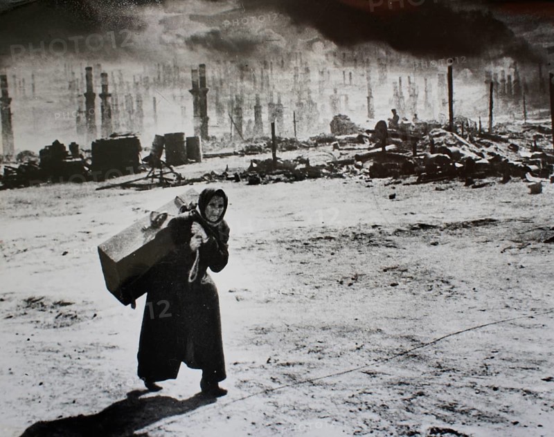 Scorched Earth, Northern Front, Murmansk, Soviet Union 1941 Variant 2 with manipulated skies J. Chaldej about this photo: 'Hitler had said: 'Murmansk must be taken. ' He wanted to prevent the British from supporting the Soviet Union. Murmansk was bombed for a year. On June 22, 1942, Hitler gave the order to burn Murmansk down for good. The city consisted primarily of wooden houses. 350, 000 incendiary bombs were dropped for a day. I discovered the old woman with her suitcase after one of the bombings in 1941. She saw that I had a camera, put down the suitcase and said: 'Aren't you ashamed to record our misfortune? '