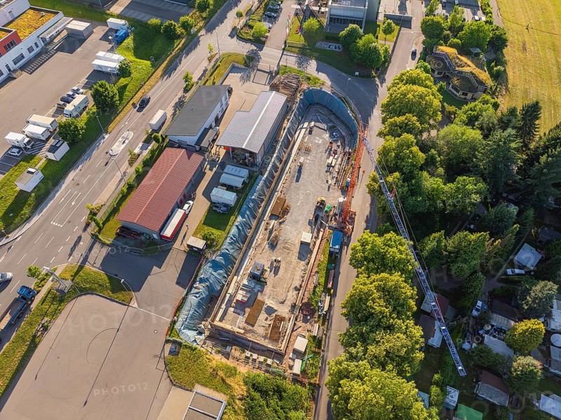Aerial view of an active construction site with construction work in an industrial environment surrounded by trees and roads, Parkhaus Bau, Calw, Germany