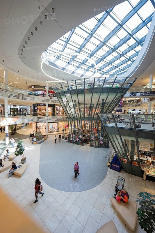 Interior of a shopping center with distinctive glass structure and hustle and bustle, Milaneo, Stuttgart, Germany