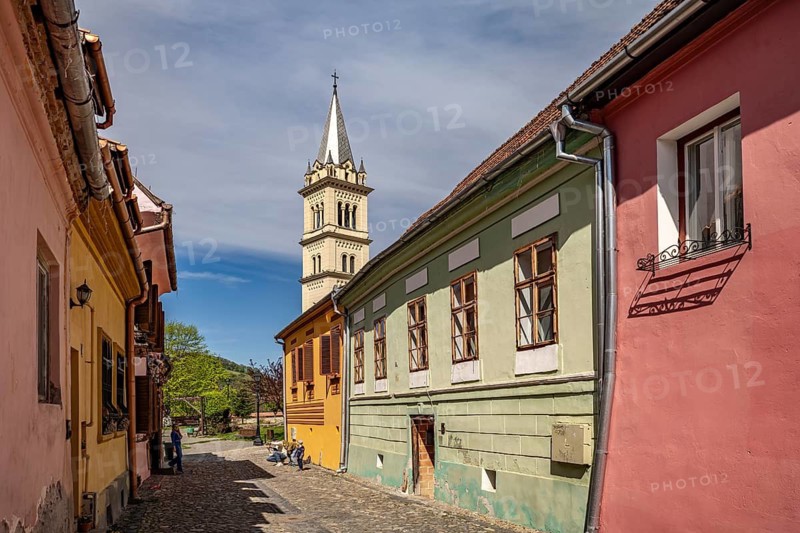 The colorful houses of the citadel and the Roman Catholic Church of St. Joseph in Sighisoara or Sighisoara, Transylvania, Romania