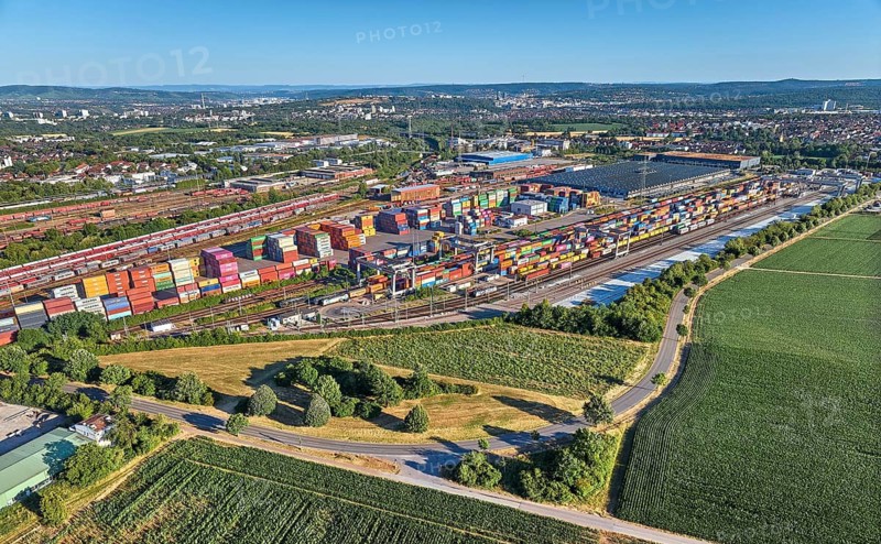 Aerial view of a large container terminal with freight trains, shipping containers, cranes, and rail logistics infrastructure surrounded by farmland. Kornwestheim, Baden-Württemberg, Germany