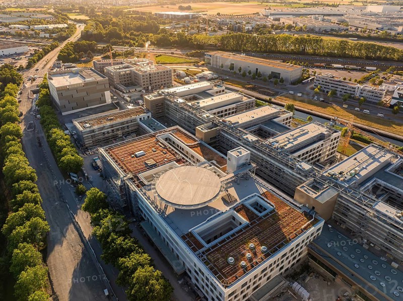 Complex of buildings in an industrial area, surrounded by trees and roads, construction site of the new airfield clinic, Böblingen, Germany