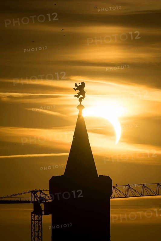 Shortly in front of sunset, the sun darkens during a solar eclipse, seen here with the Warsaw Bridge in Berlin Friedrichshain on 12/08/2026