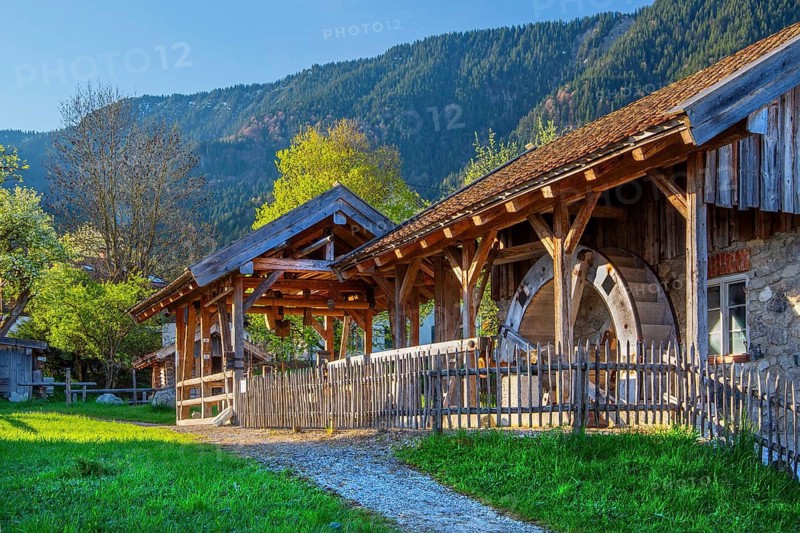Historic Schleifmühle, water mill, in the village in spring, Ohlstadt, Loisach Valley, The Blue Land, Upper Bavaria, Bavaria, Germany
