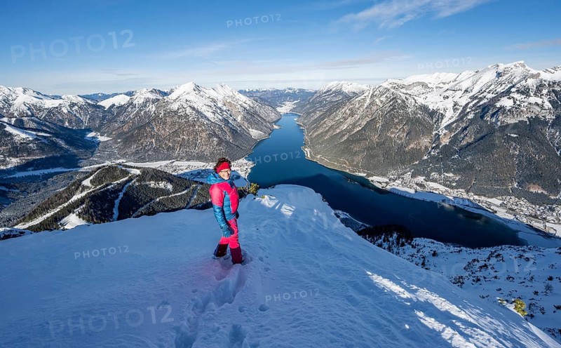 Picturesque view of Achensee and wintry mountain scenery, ski tourer at the summit of Bärenkopf, Achensee, Tyrol, Austria