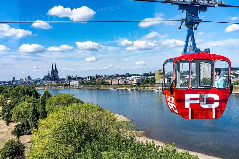 Ride on the Cologne cable car, between Zoo and Deutz, view of the Rhine Park on the right side of the Rhine, Cologne-Deutz, Cologne Cathedral, summer, dried meadows, trees on the banks of the Rhine, North Rhine-Westphalia, Germany