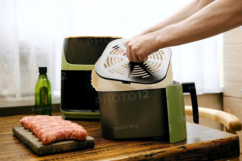Placing parchment paper under crisper tray of air fryer basket to ensure proper circulation of hot air while cooking food