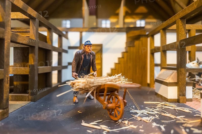 Miniature illustration of a farmer with straw and wooden cart