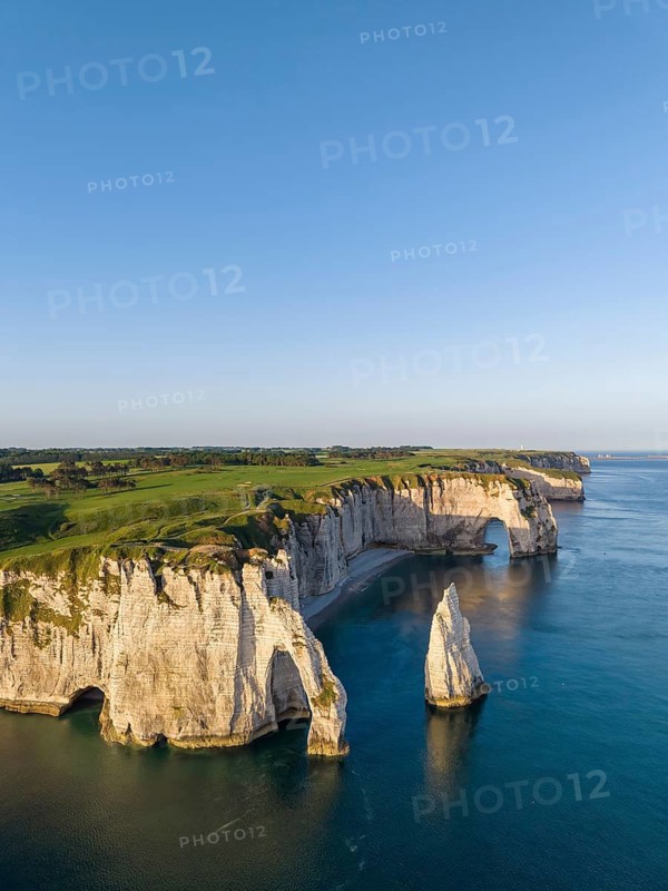 Aerial view of the Porte d'Aval rock formation in the evening sun, well-known sights on the chalk coast with the distinctive Aiguille d'Étretat rock formation, behind it the La Manneporte rock gate and the Pointe de la Courtine ledge, then Pointe du Fourquet, right on the cliffs of the Golf d'Ètretat golf course founded in 1908, Alabaster Coast, La Côte d'Albâtre, chalk cliffs, English Channel, Seine-Maritime, Normandy, France