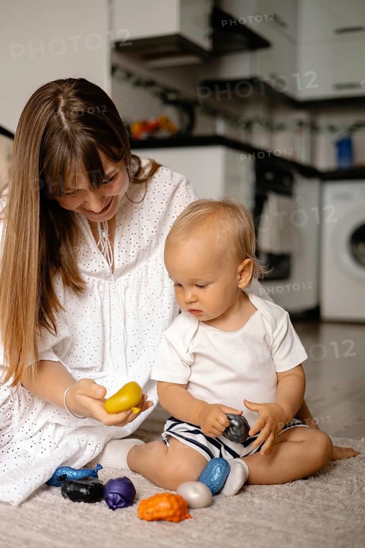 Mother and child holding toys and interacting in a cozy room