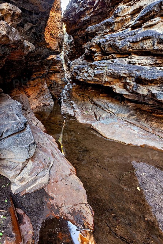 A narrow gorge with water on the ground surrounded by imposing rocks, deep gorge in the thornshrub savanna of Caatinga in the federal states of Pernambuco and Bahia in Brazil
