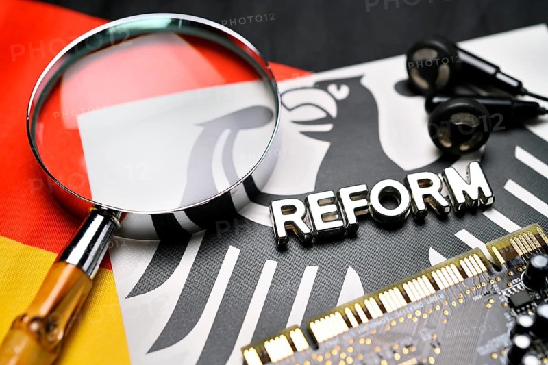Reform lettering, magnifying glass and computer board on federal eagle and German flag, symbolic photo of German secret service reform +++ editorial use only