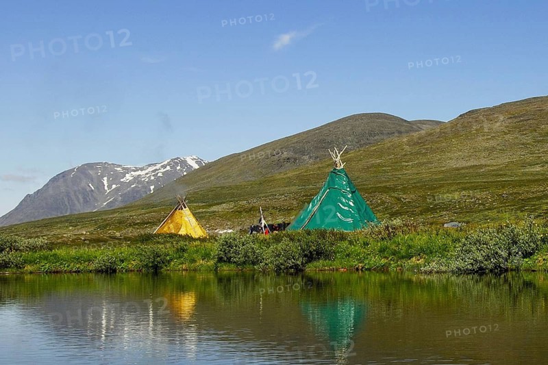 Sami tent droppings are reflected in a lake, on the left the Akka massif in Stora Sjöfallet N.P, Lapland, Sweden