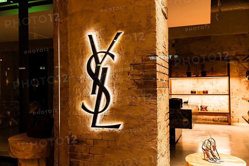 Vienna, Austria - 15 December, 2025: Illuminated YSL logo on a textured wall in Vienna, Austria. The logo is prominently displayed, showcasing the brands iconic design