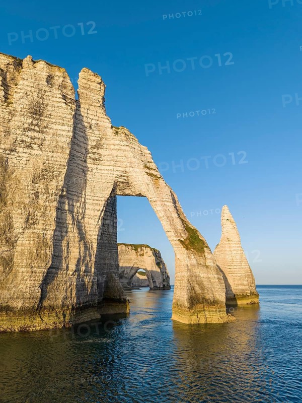 Aerial view of the Porte d'Aval rock formation shortly after sunrise, well-known landmark on the chalk coast with the distinctive Aiguille d'Étretat rock pin, behind it the La Manneporte rock gate, Étretat, Alabaster Coast, La Côte d'Albâtre, chalk cliffs, English Channel, Seine-Maritime, Normandy, France