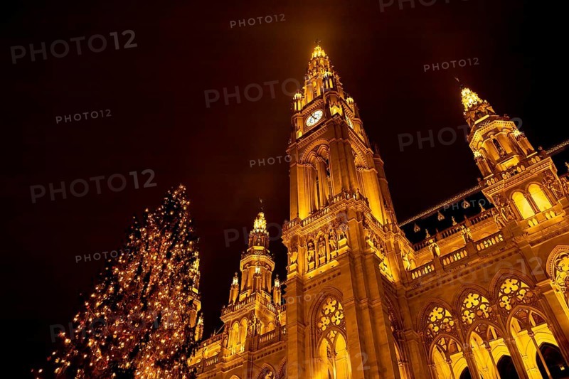Vienna, Austria - 15 December, 2025: Illuminated city hall in Vienna, Austria, with a decorated Christmas tree in the foreground. The scene captures the festive atmosphere of the holiday season