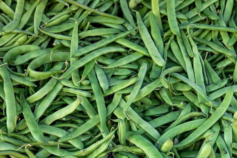 A heap of fresh green beans on display at a market