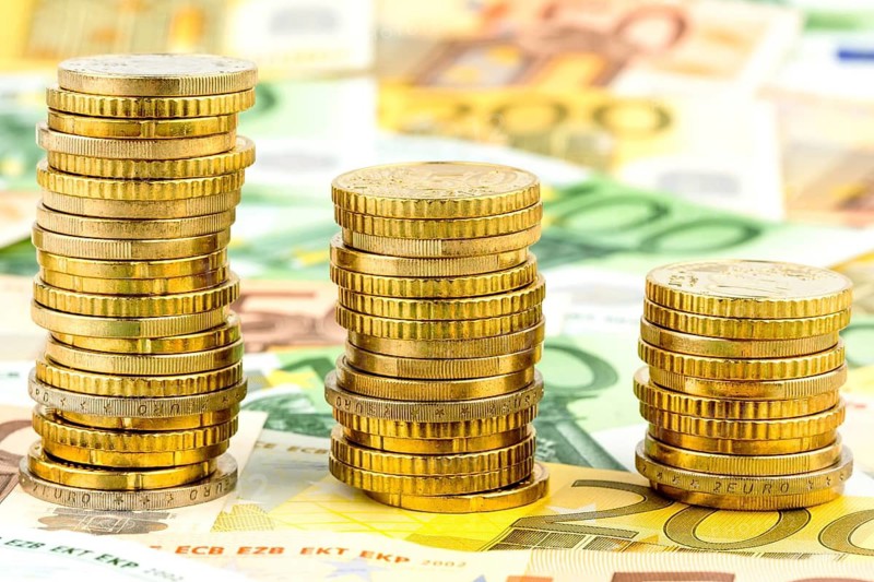 Stack of coins, sinking curve, symbolic photo of falling interest rates and falling costs, cents, euros, euro cents