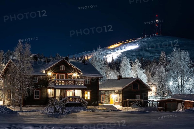 Illuminated house in snow with Mount Dundret, Gällivare, Norrbotten, Lapland, Sweden
