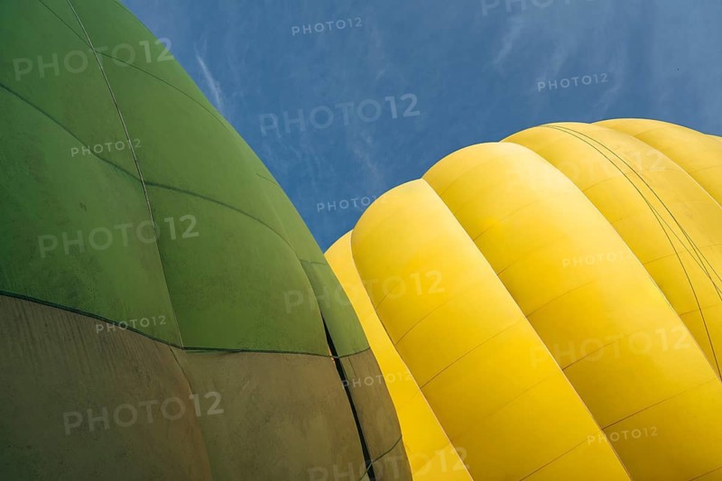 Yellow and green hot air balloons against clear blue sky, partial view, Close-up of vibrant green and yellow hot air balloons against a clear blue sky, Vilnius, Lithuania