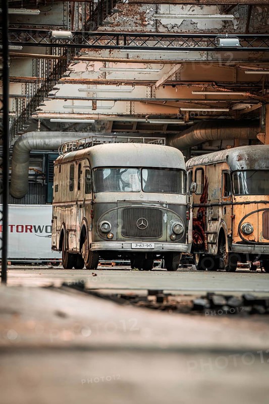 Two old, rusty Mercedes trucks in an abandoned factory building with industrial and nostalgic flair, Motorworld, Rüsselsheim, Germany