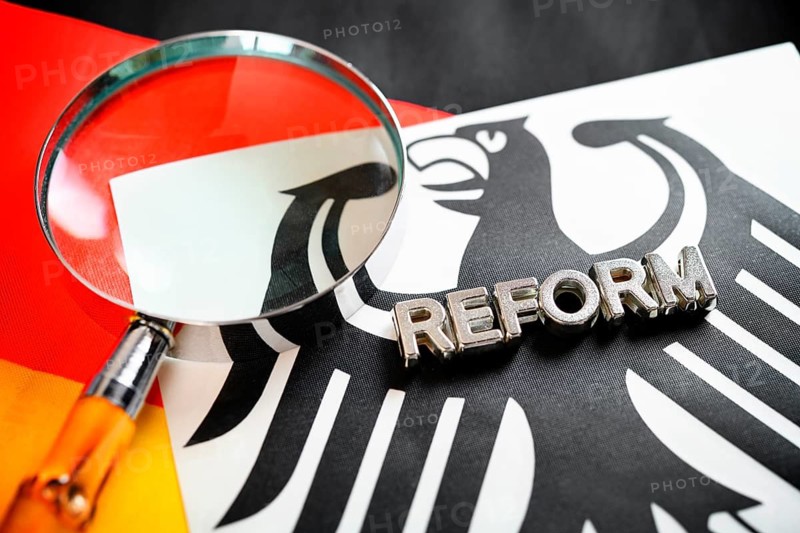 Reform and magnifying glass lettering on federal eagle and German flag, symbolic photo of German secret service reform +++ editorial use only