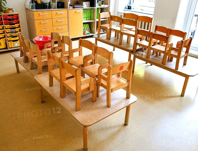 High-standing wooden chairs in the empty group room of a daycare center, Berlin, 11.08.2026, Germany