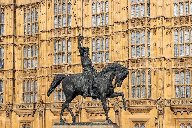 Richard the Lionheart's bronze equestrian statue by Carlo Marochetti stands before the Gothic Revival Houses of Parliament, London, England, United Kingdom