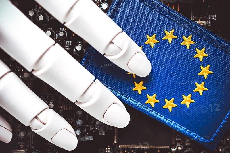 Robot hand on computer board and EU flag, EU AI Act symbol photo +++ editorial use only