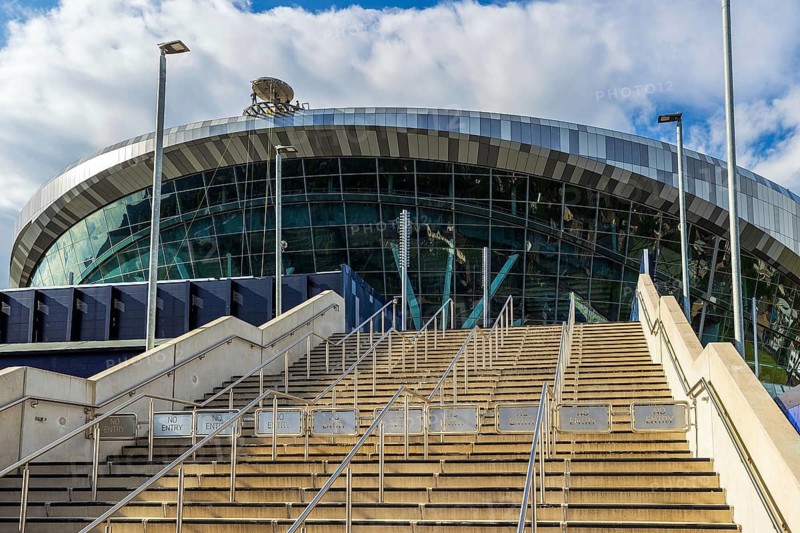 A wide stone stairway rises toward the glazed bowl of Tottenham Hotspur Stadium, London, England, United Kingdom