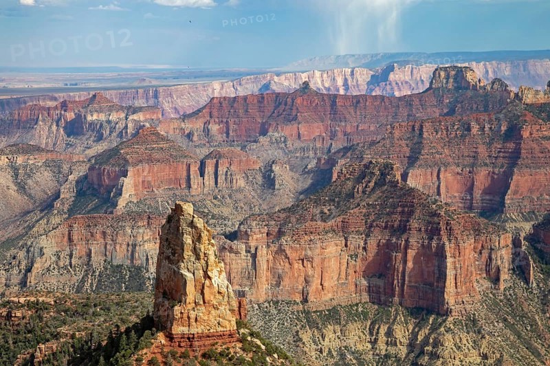 Grand Canyon National Park, Arizona - The rock pinnacle Mount Hayden rises about 5, 000 feet from the canyon floor near Point Imperial on the North Rim. A storm drops rain south of the Canyon