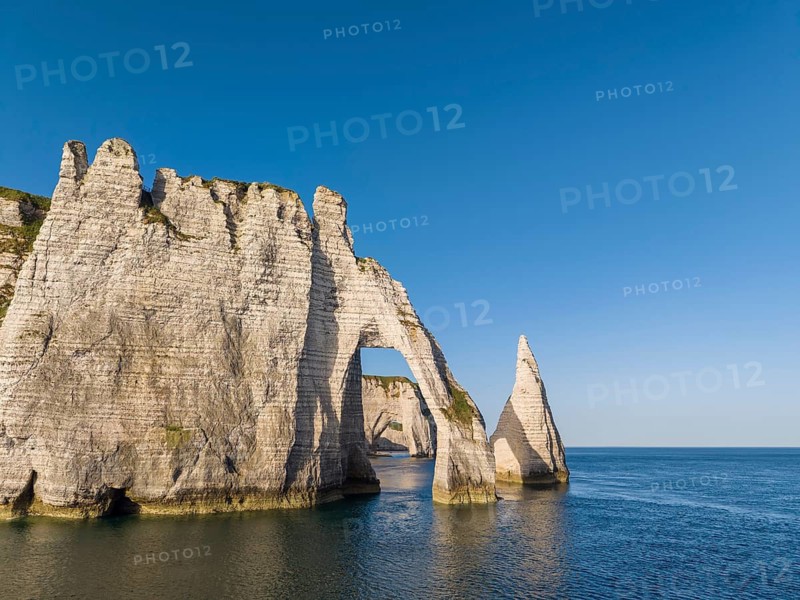 Aerial view of the Porte d'Aval rock formation with the free-standing Aiguille d'Étretat rock pin in the morning sun, well-known sights and natural beauty on the chalk coast, behind it the La Manneporte rock gate, Étretat, Alabaster Coast, La Côte d'Albâtre, chalk cliffs, English Channel, Seine-Maritime, Normandy, France