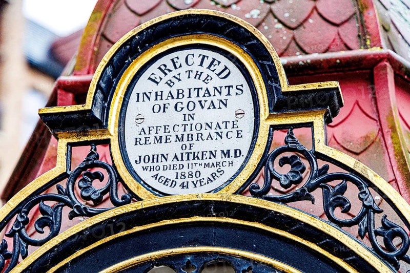 Close up of the gilded dedication plaque honouring Dr John Aitken on the Victorian memorial fountain, Govan Cross, Glasgow, Scotland, United Kingdom