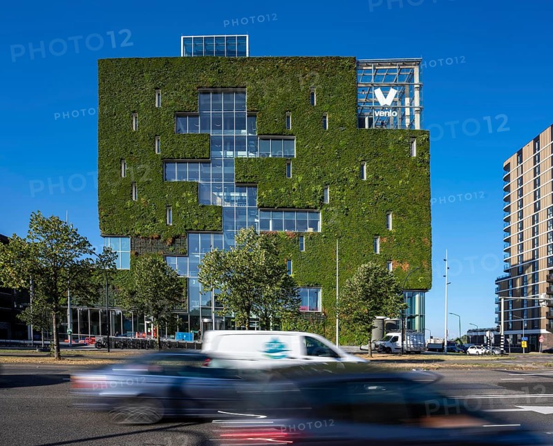 Green north façade of Stadskontoor Venlo, city administration building, from 2016, approx. 2200 square meters of the façade are green, various types of plants hang in plant modules in front of the actual façade, a combined climate concept, a circulatory system, with a greenhouse on the upper floors, thermal energy from the underground parking garage, a so-called solar chimney, is the building air cooled in summer and heated in winter, rainwater is used to irrigate the green building façade, the entire project was built according to the Cradle-to CRADLE concept built, Venlo, Limburg, Netherlands