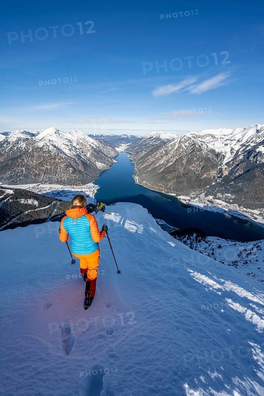 View of Achensee and wintry mountain scenery, ski tourer at the summit of Bärenkopf, Achensee, Tyrol, Austria